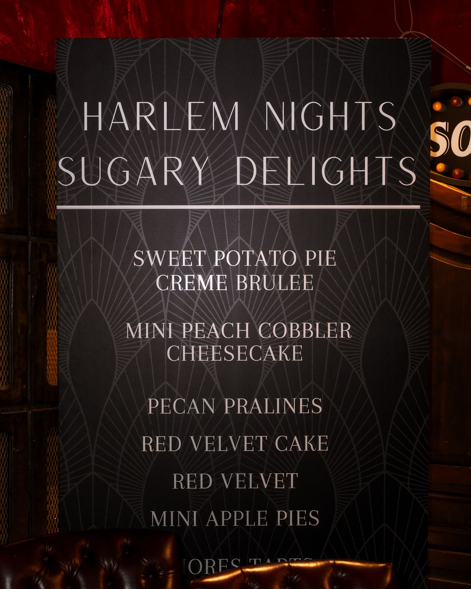 Menu board listing Harlem Nights Sugary Delights dessert options including sweet potato pie and red velvet cake.