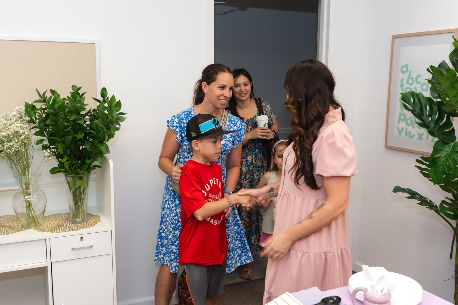 A casual gathering in a bright room with floral arrangements and modern decor.