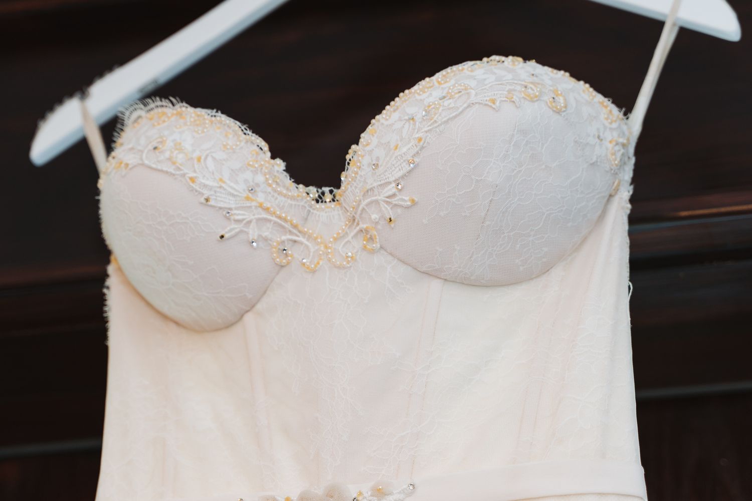 Close-up of white strapless wedding dress bodice with delicate beaded details.