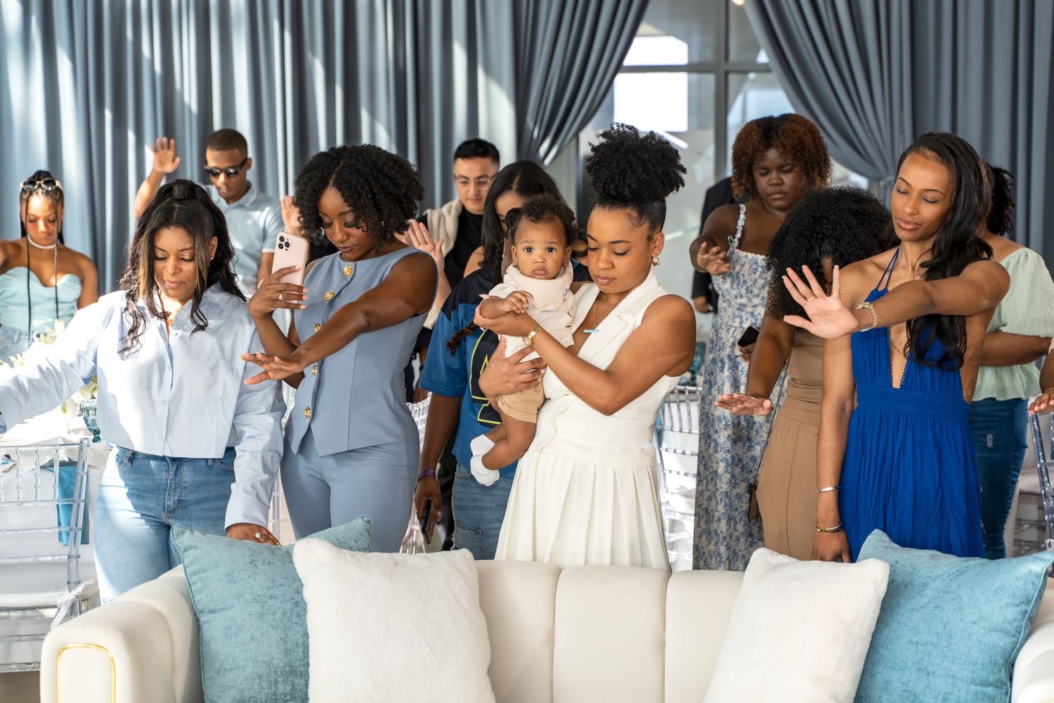 Group of guests enjoying celebration in modern event space with blue decor.