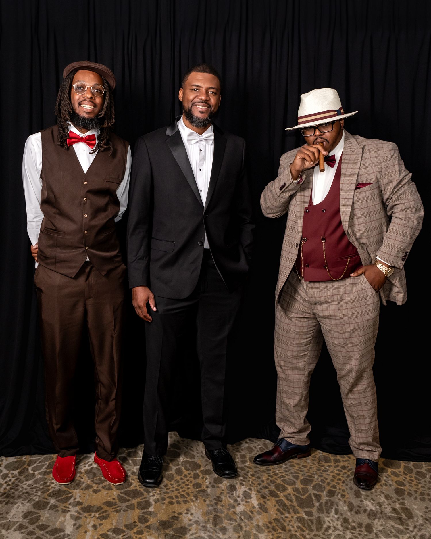Three men pose in stylish formal wear including bow ties and coordinated suits.