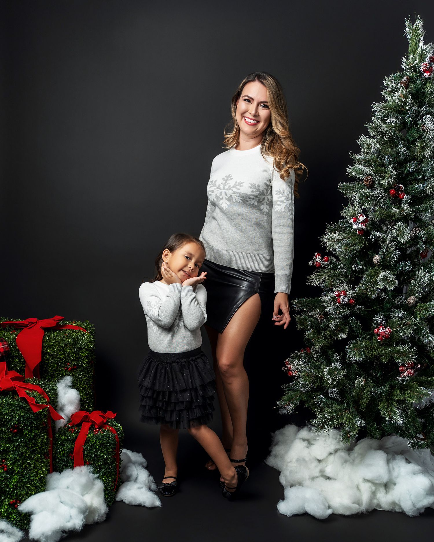 Mother and daughter in coordinated white and black outfits posing by decorated Christmas tree.Lifestyle family photography session in West P