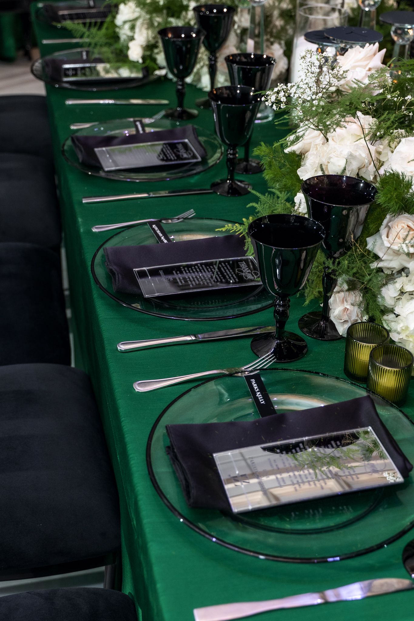Green tablecloth dining setup with keyboards and place settings decorated with white floral arrangements.