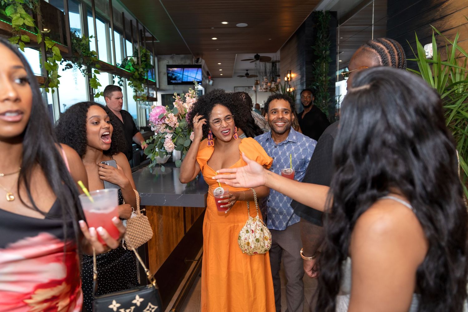 A lively indoor celebration with guests mingling and dancing at a party venue.