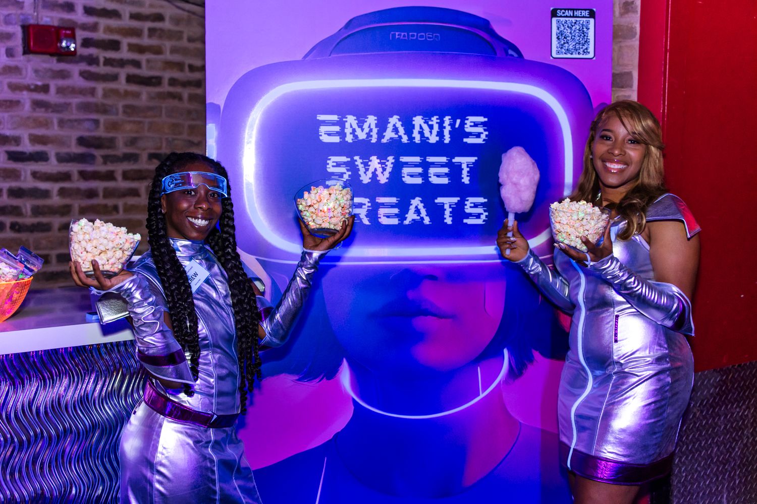 Event setup with purple neon sign reading Emani's Sweet Treats and staff in metallic outfits.