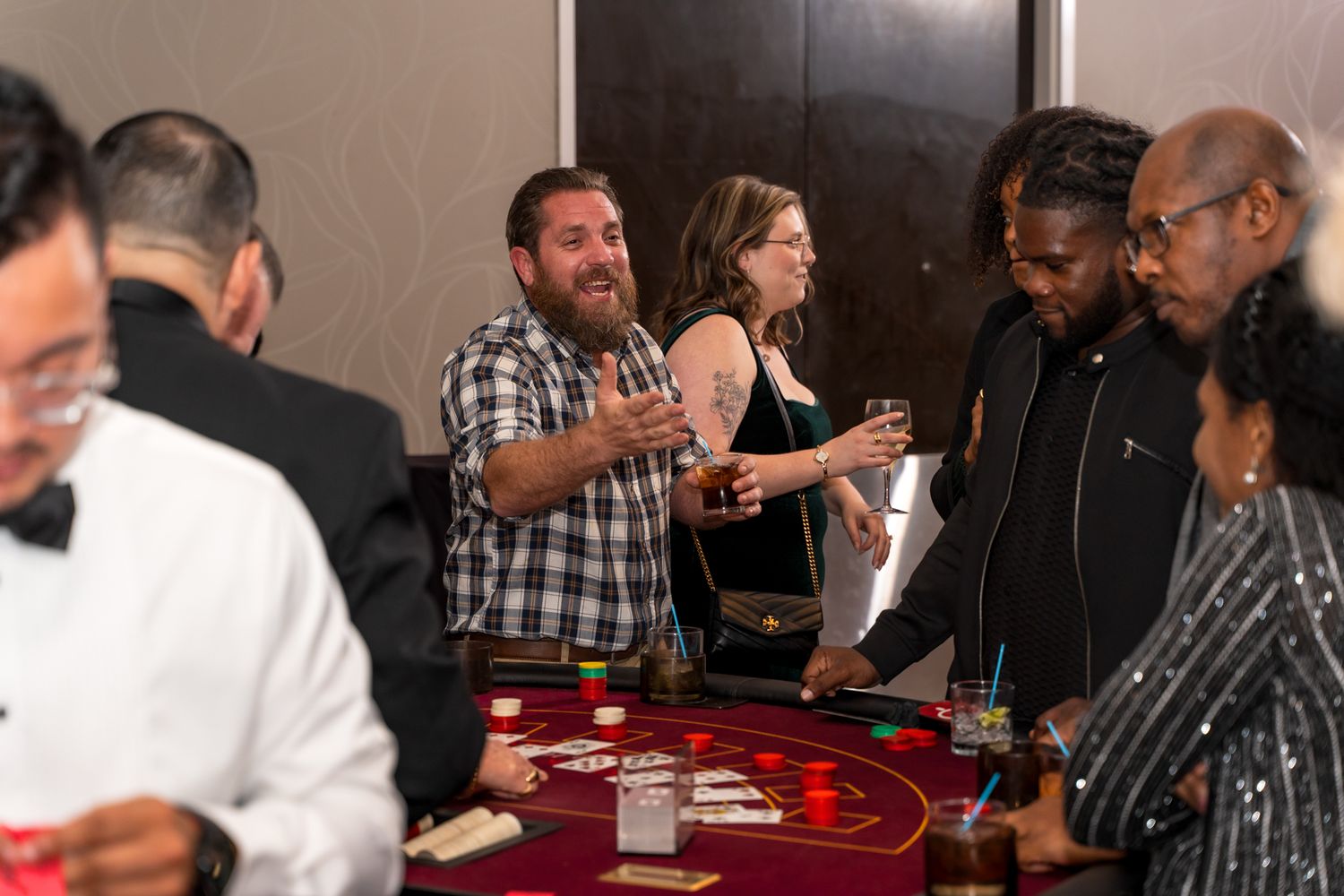 Group gathered around a casino gaming table during an evening entertainment event.