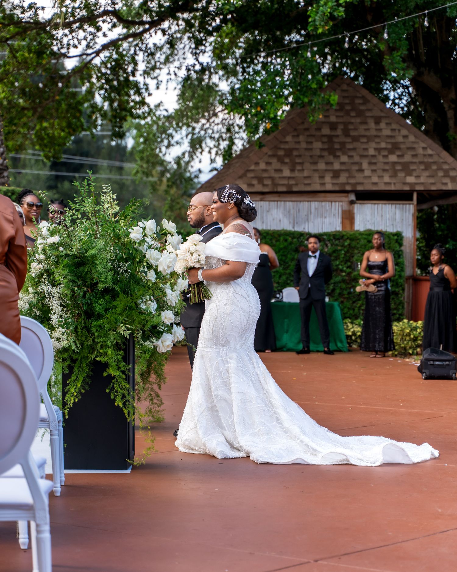 Wedding celebration on an outdoor terrace with string lights and floral decorations.