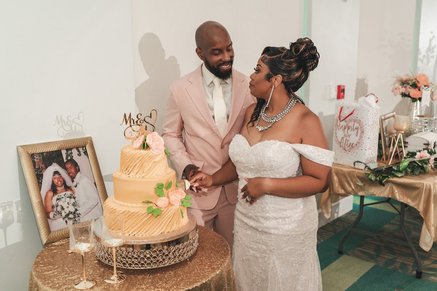 Newlyweds cut their elegant tiered wedding cake decorated with flowers.