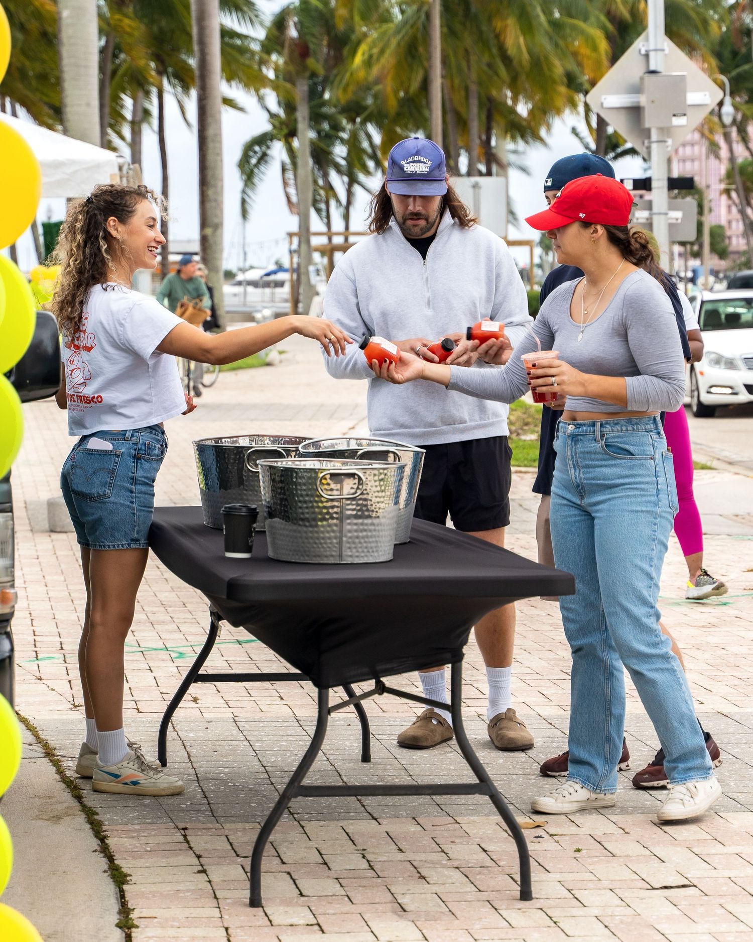 Outdoor refreshment station with drinks being served at tropical venue.