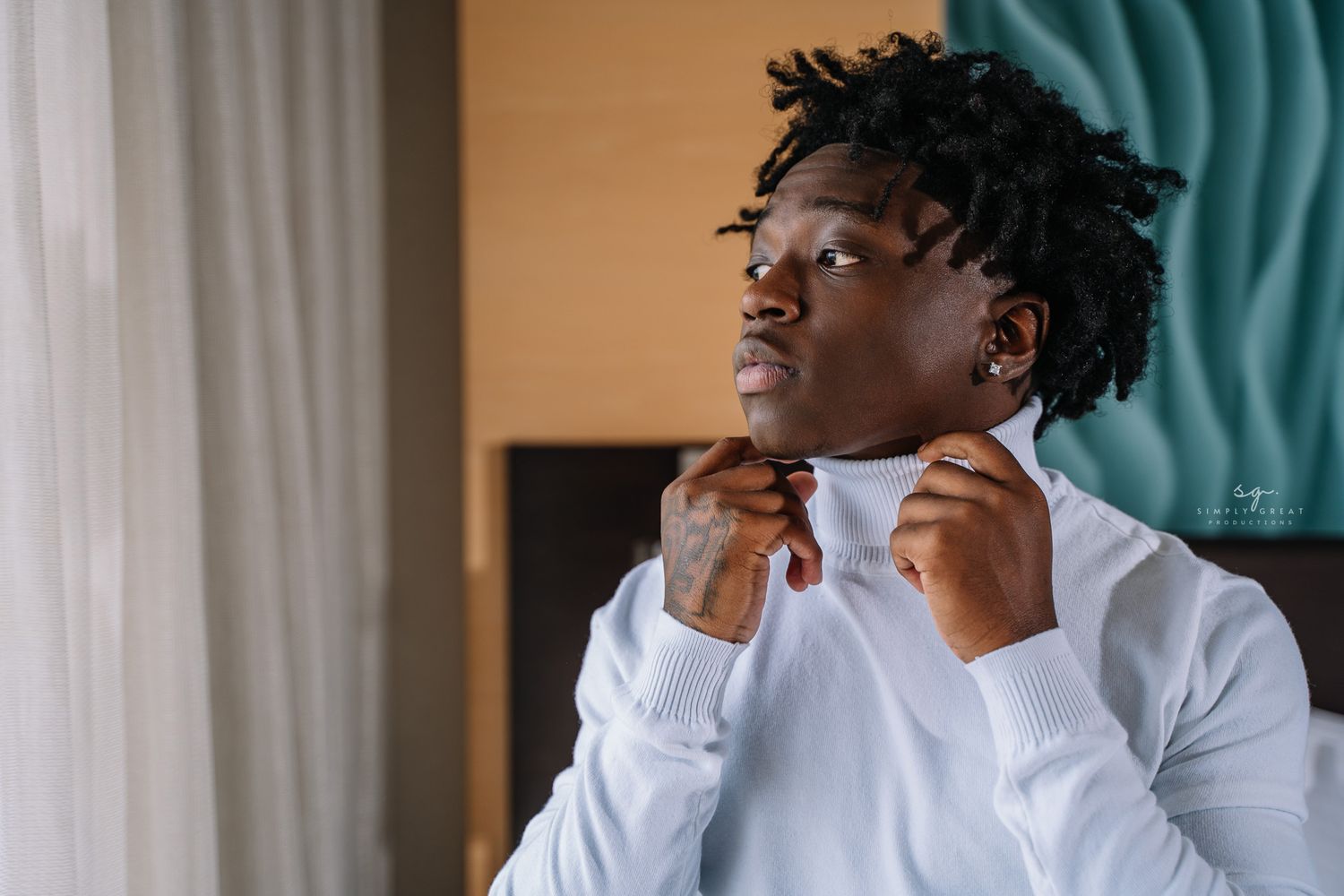 A person in a crisp white dress shirt adjusts their tie.