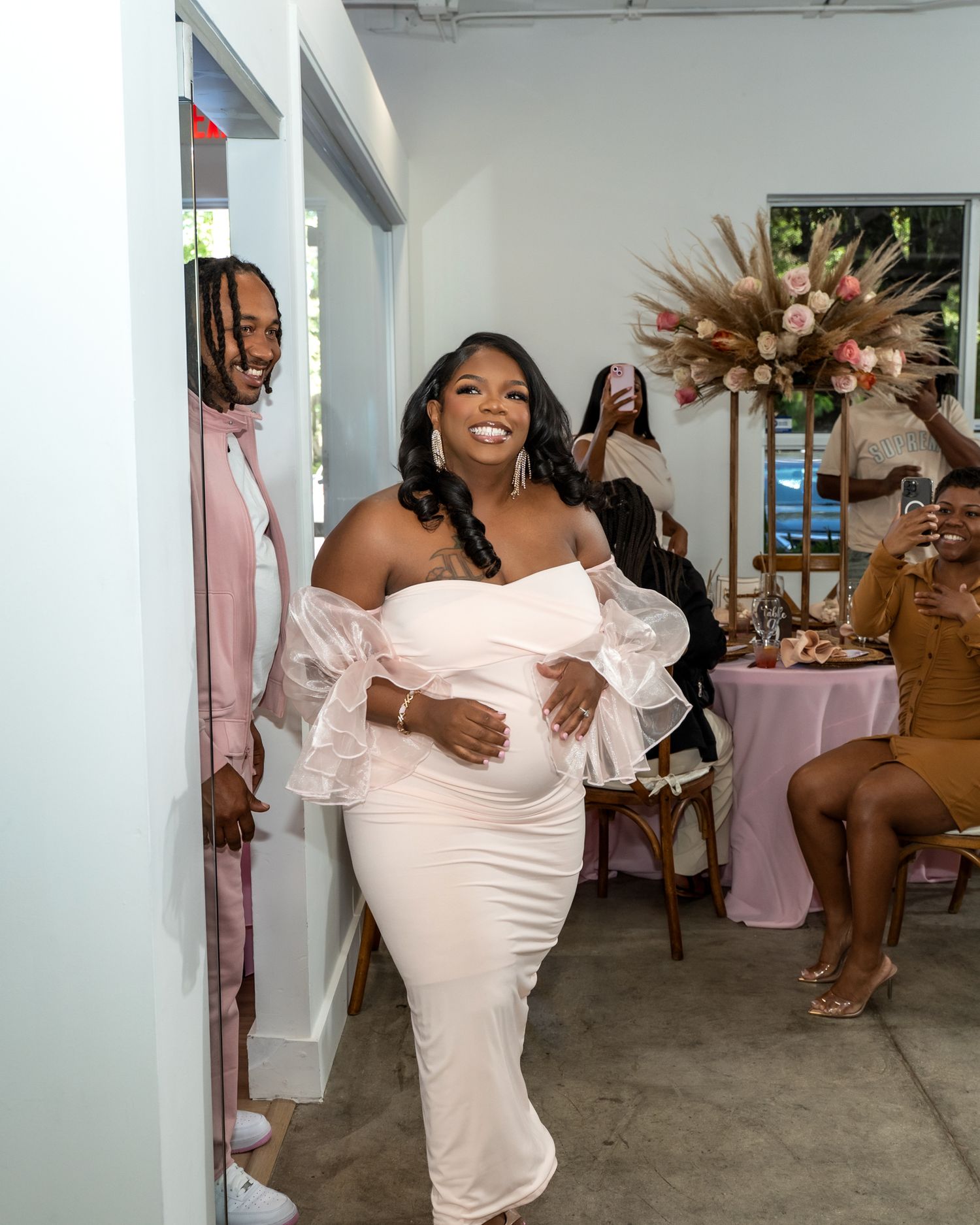 Celebratory moment at an elegant baby shower with pink decor and floral arrangements.