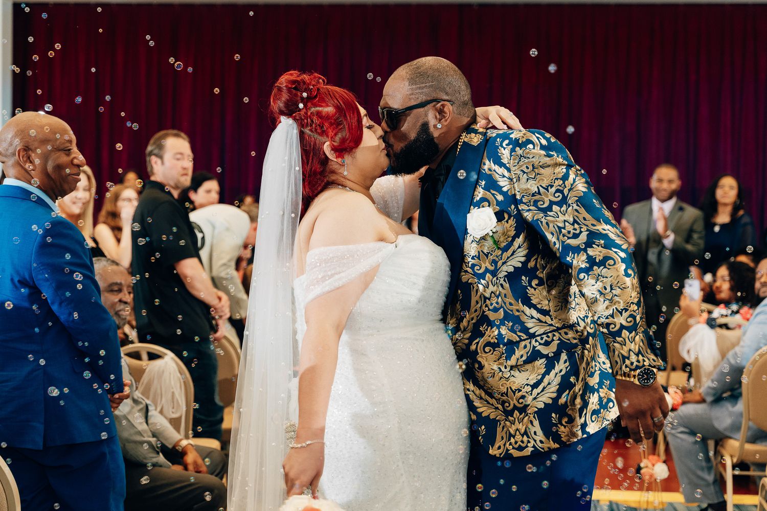 A couple sharing an intimate moment during their wedding ceremony under twinkling lights.