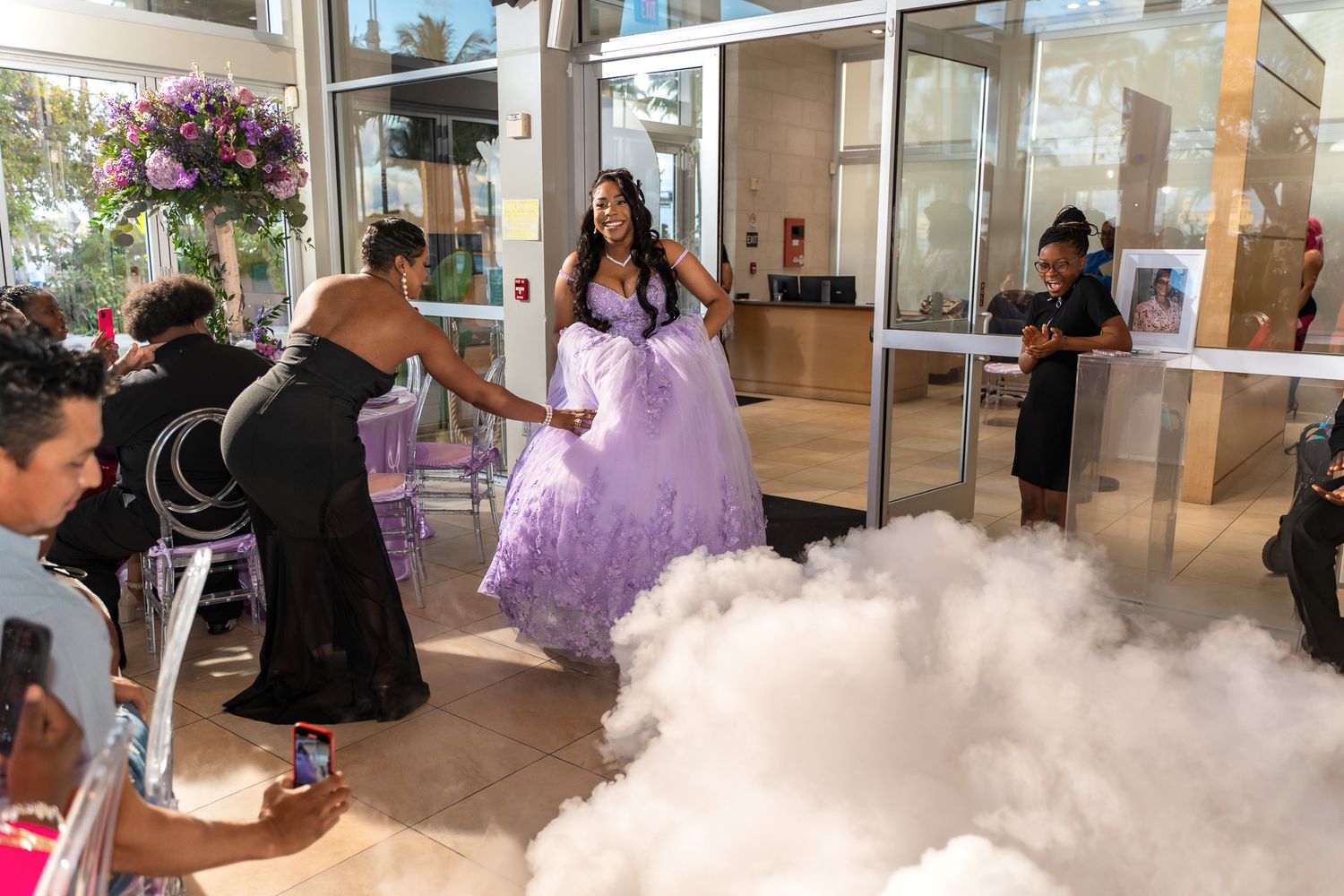A photographer captures a festive moment with fog effects at a formal celebration.