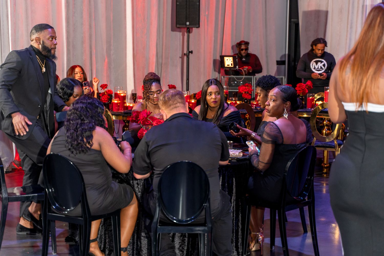 Event guests seated at tables during social gathering with ambient lighting.