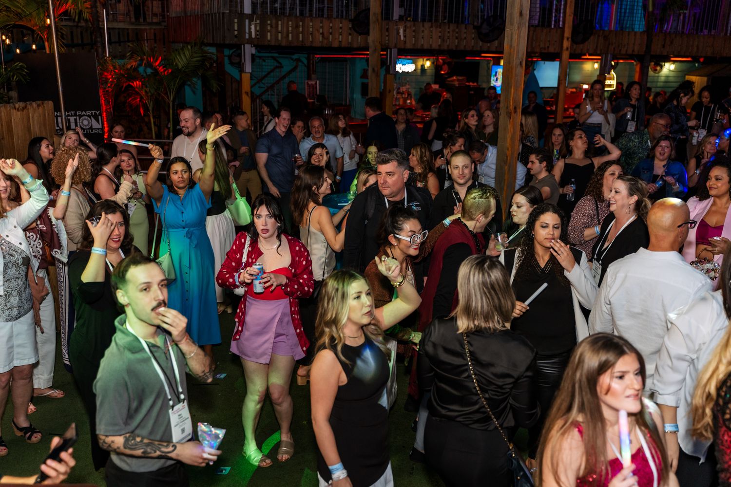 A crowded dance floor filled with people enjoying themselves at a nighttime event.
