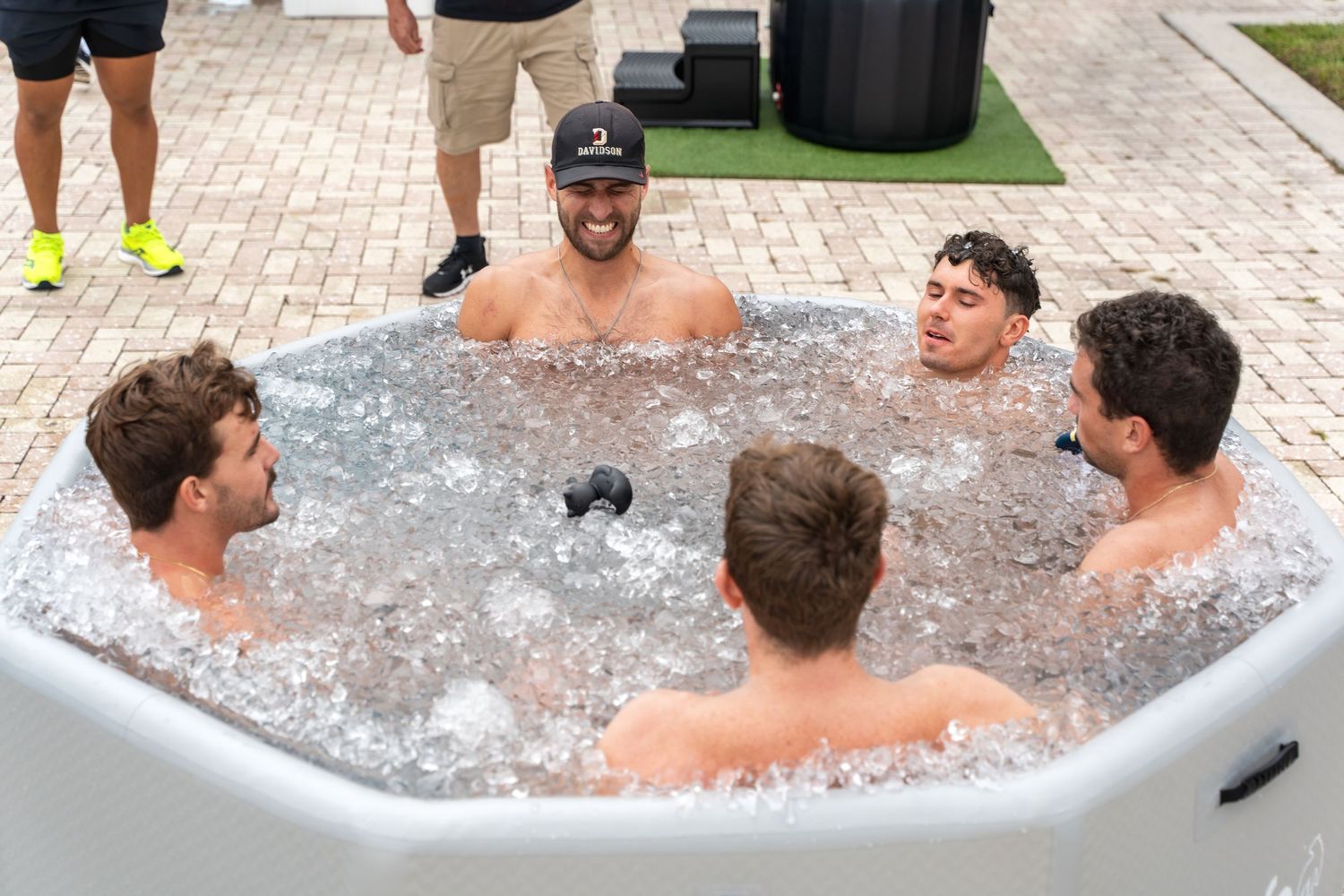 Multiple people enjoying a social gathering in an outdoor hot tub.