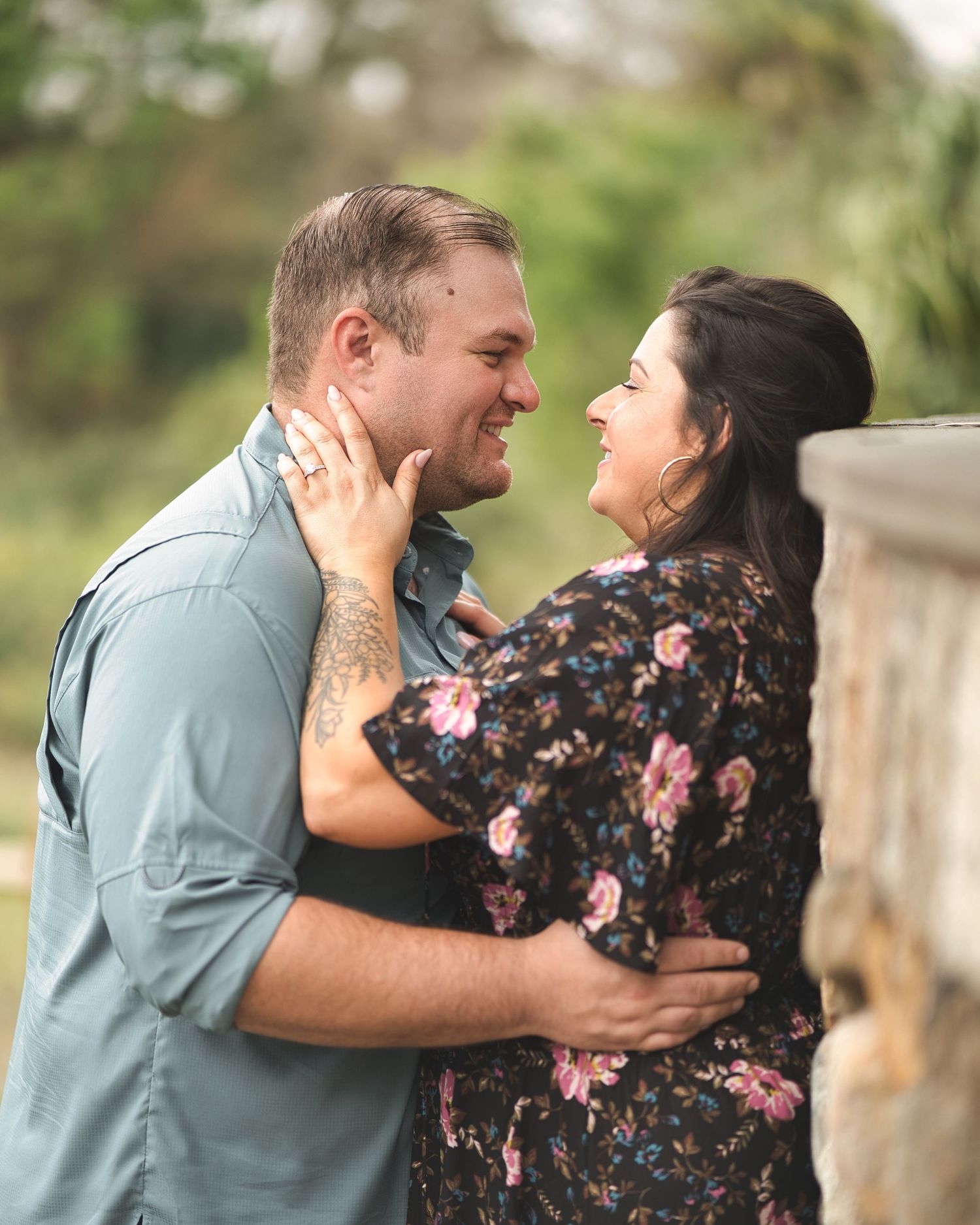 Intimate moment between couple sharing a laugh in an outdoor setting.