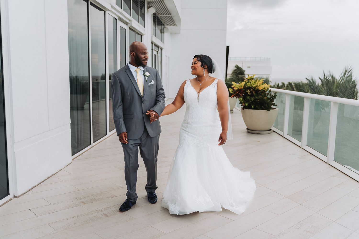 Couple shares romantic moment while walking on modern balcony.