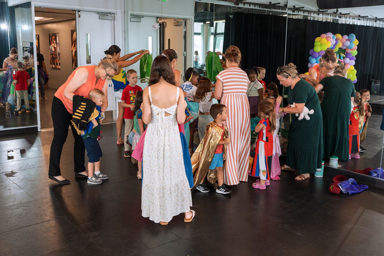 Children and adults gathered at a princess-themed party with colorful decorations.