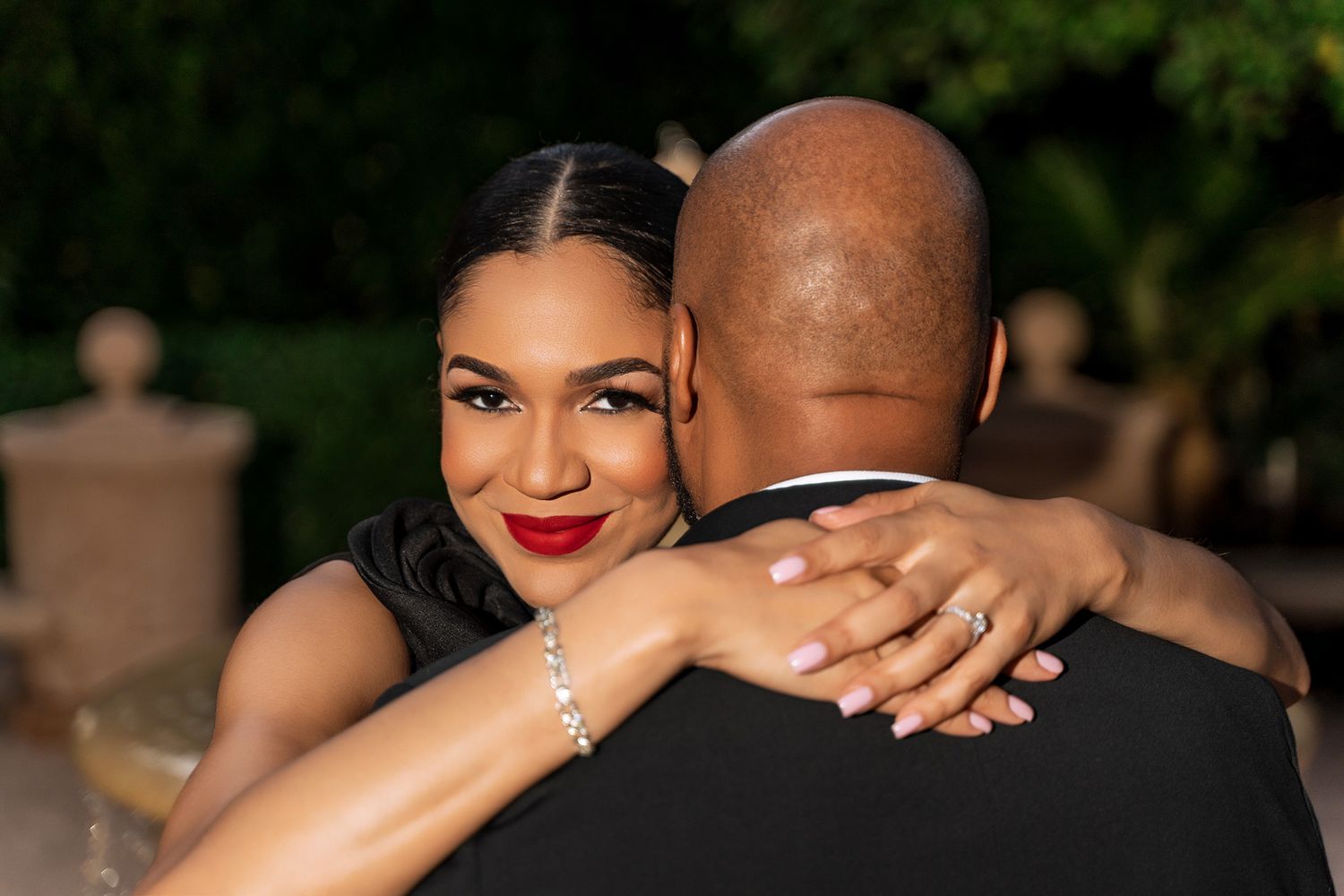 Romantic couple embrace during outdoor evening photoshoot.