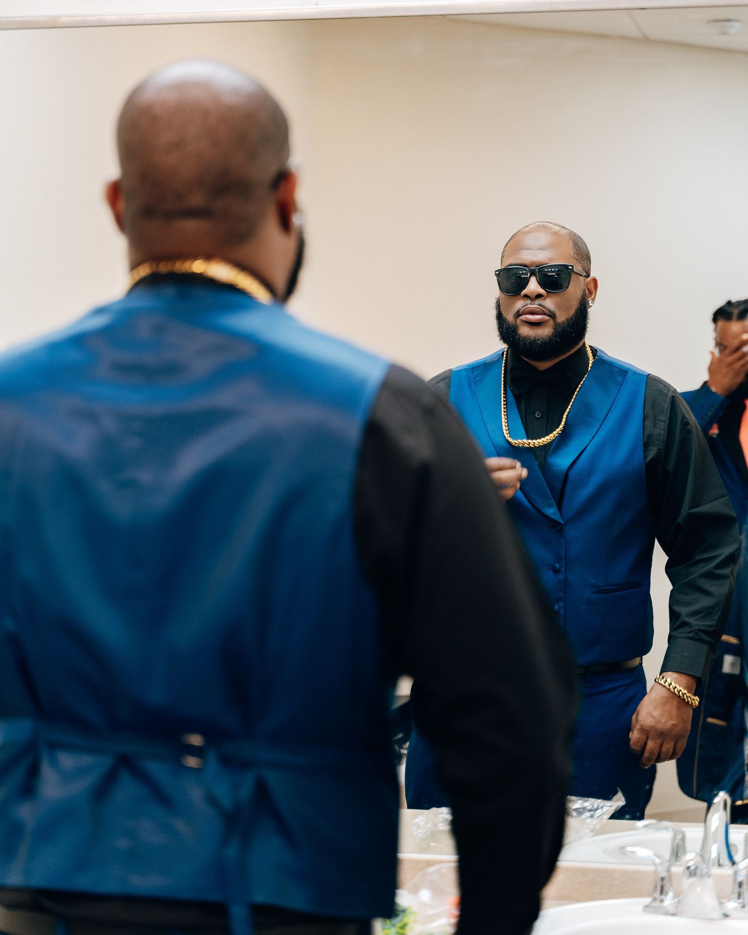 Two people in blue formal wear having a conversation at an event.