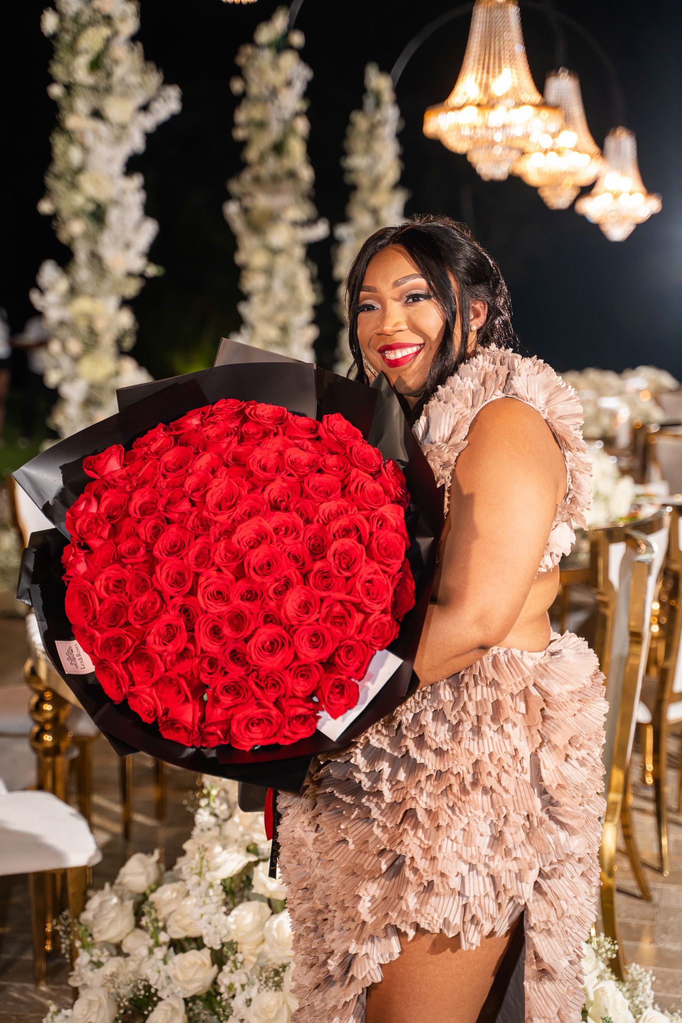 Stunning bouquet of red roses presented at an elegant evening celebration.
