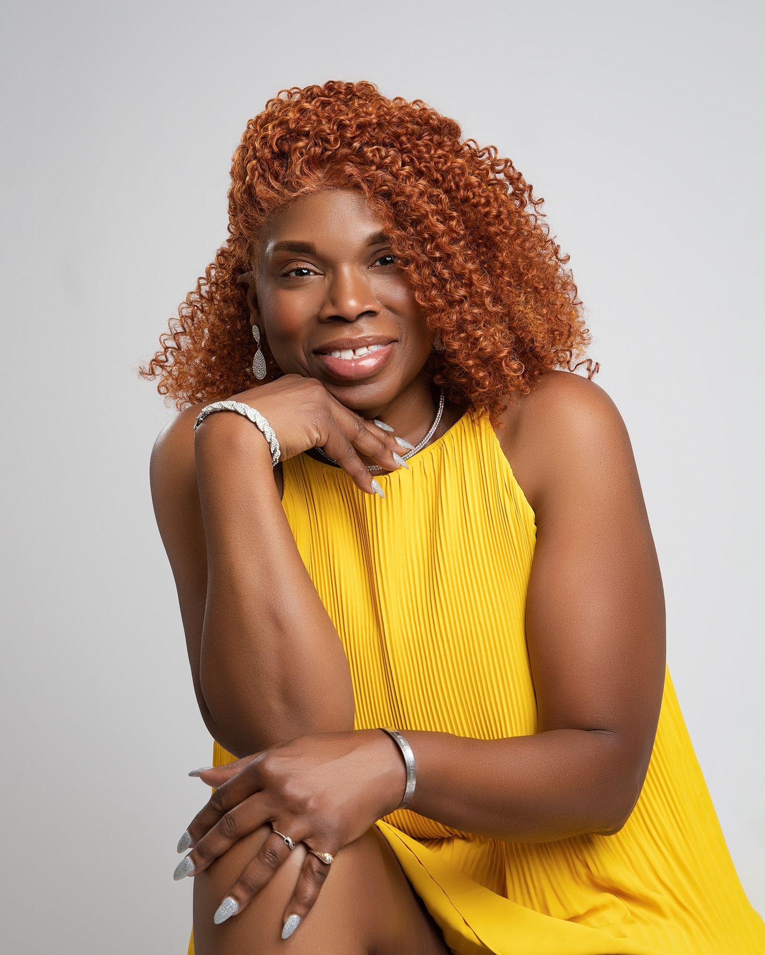 Bright yellow sleeveless dress shown in professional studio portrait.