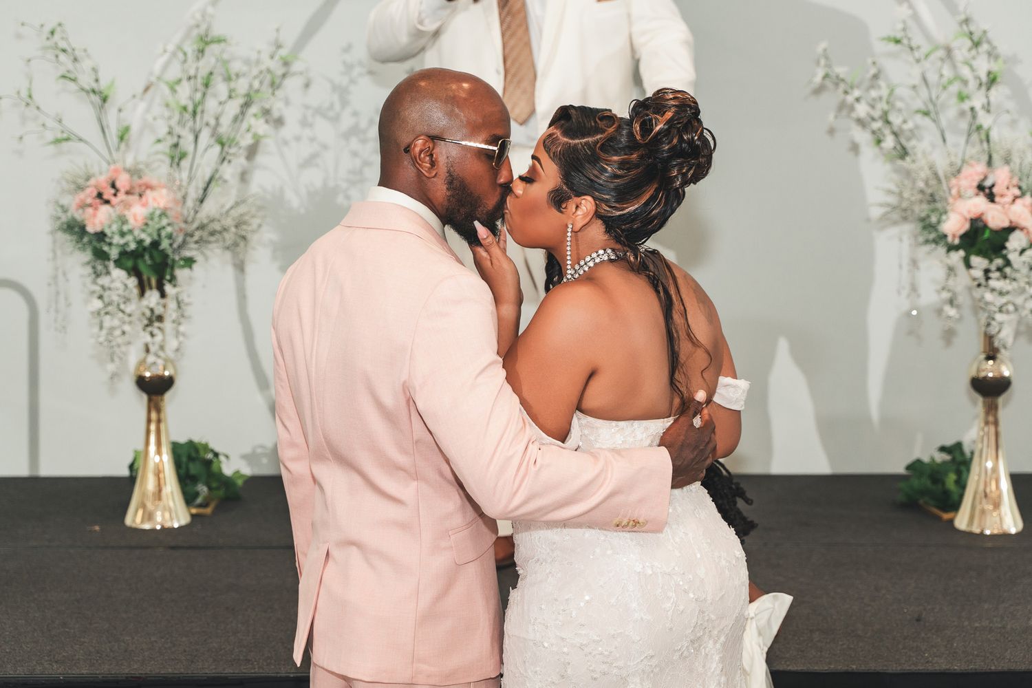 Intimate moment between newlyweds during their wedding ceremony with floral decorations.
