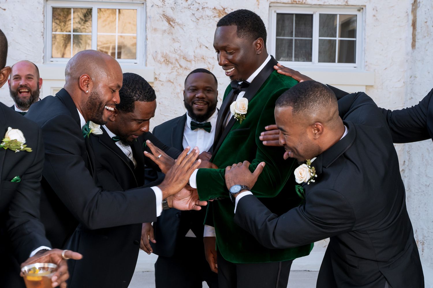 Wedding party members share an energetic celebratory moment in formal attire.