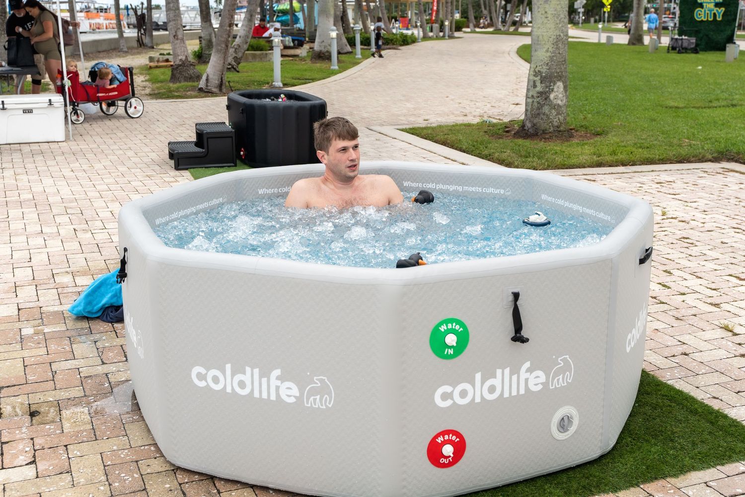 A portable cold plunge tub set up outdoors with someone enjoying a cold soak.
