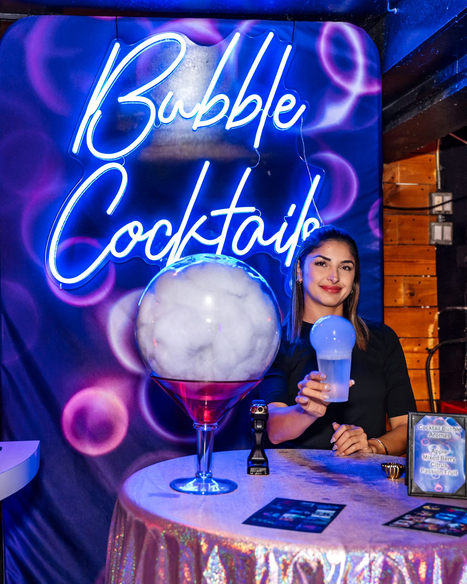 Bubble cocktails neon sign display with large martini glass decoration.