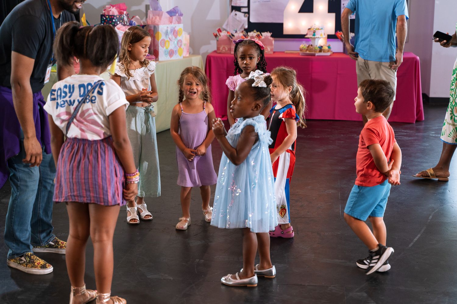 Children and adults interact during a casual gathering in a modern indoor space.