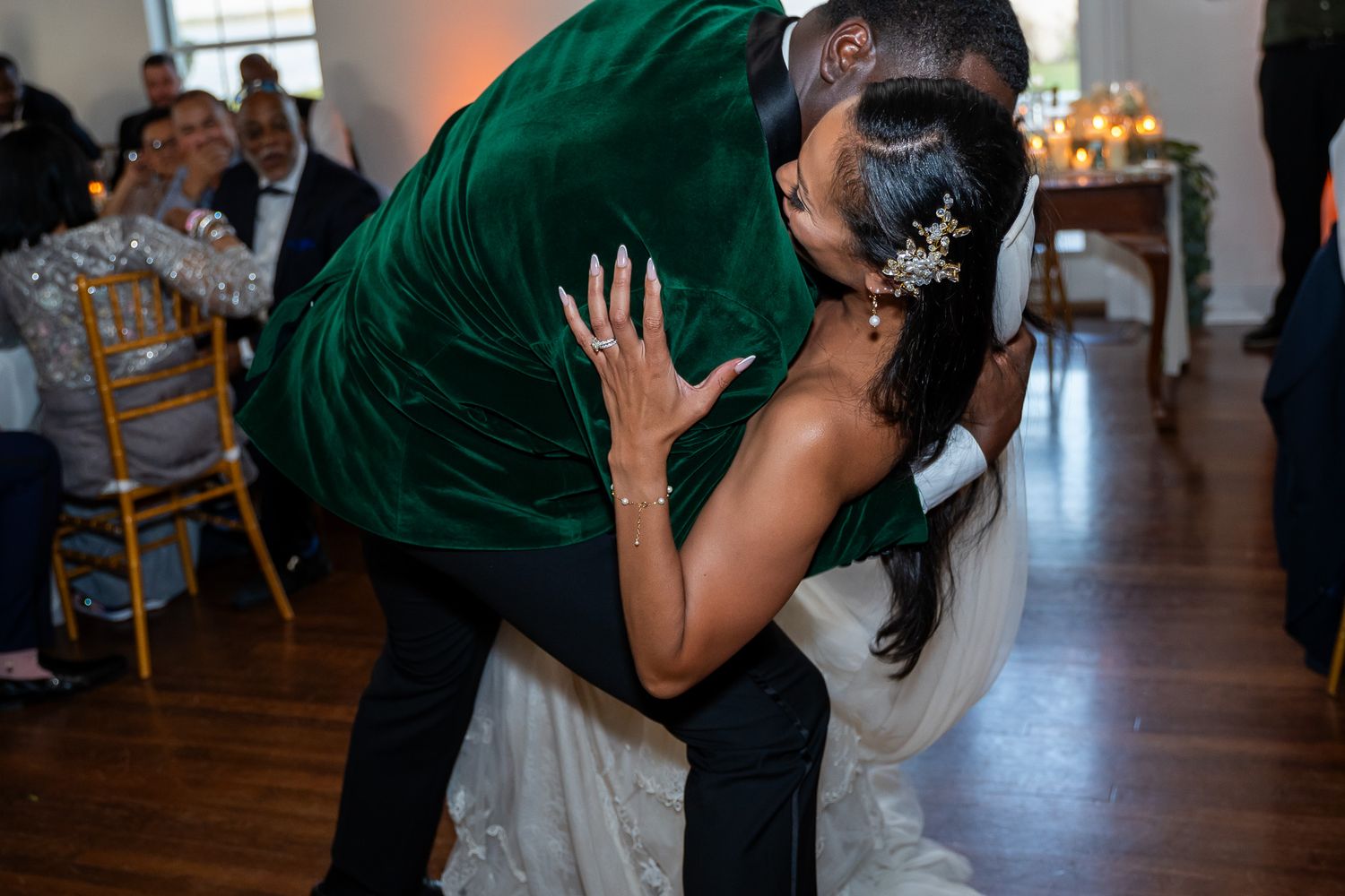 Couple shares romantic dip dance move in formal attire during wedding reception.