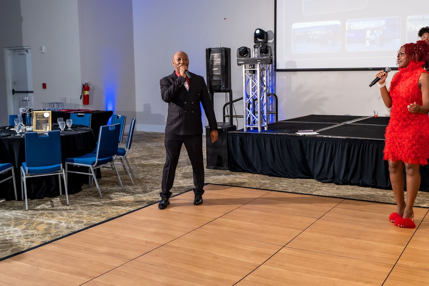 Performers entertain guests on a wooden dance floor at an elegant reception.