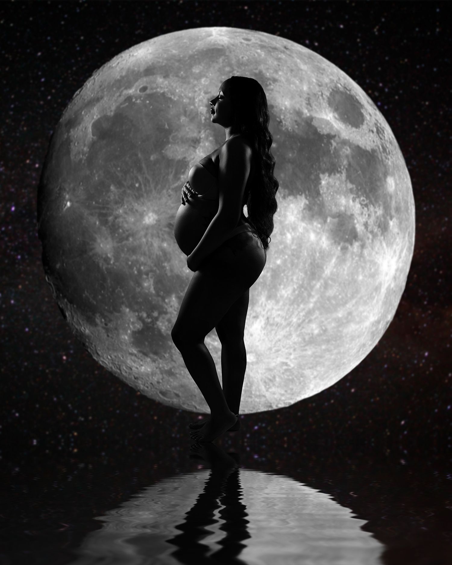 Artistic silhouette of expecting mother against large full moon backdrop with water reflection.
