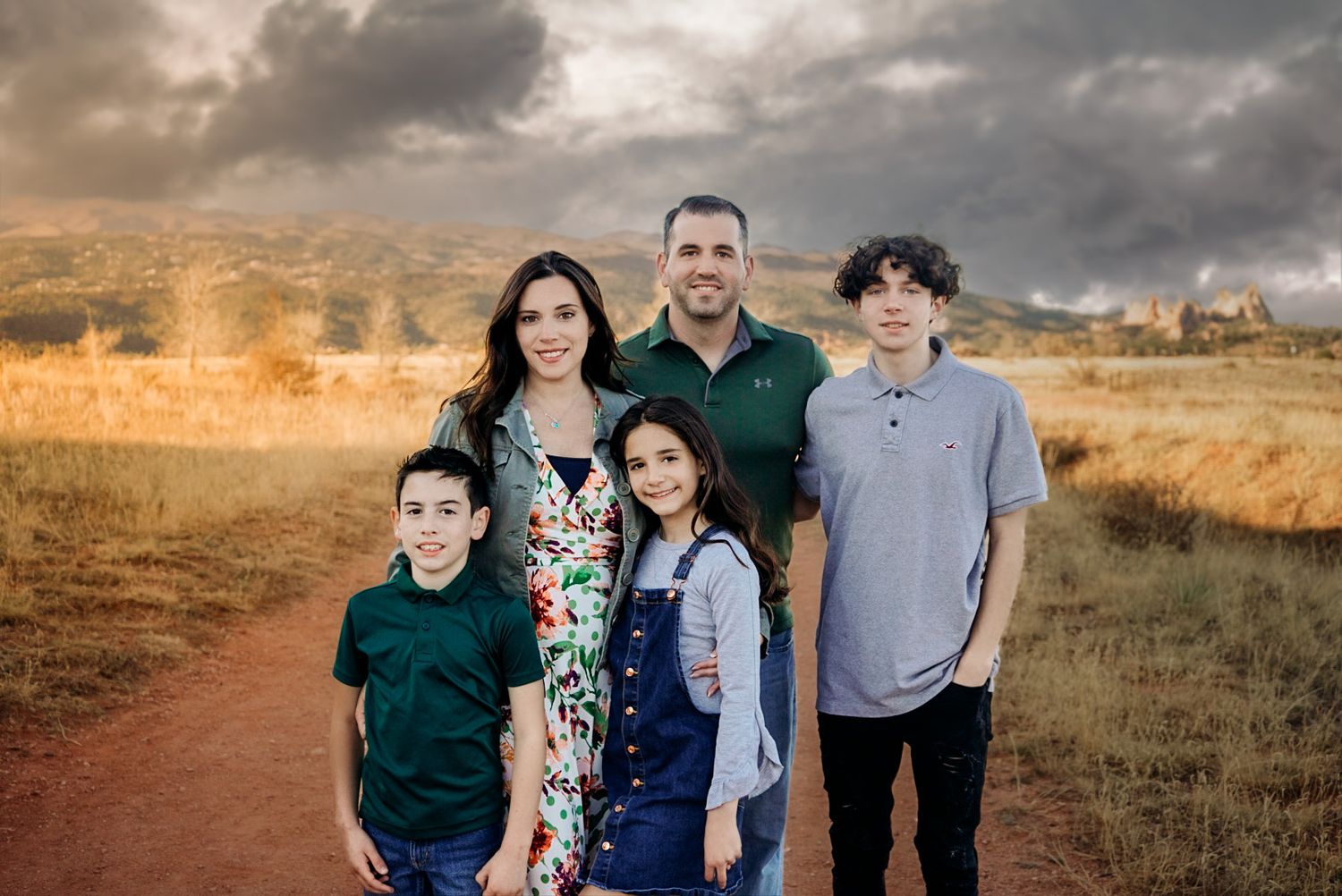 A series of family portrait photos taken outdoors at sunset with a warm golden sky and natural landscape backdrop.