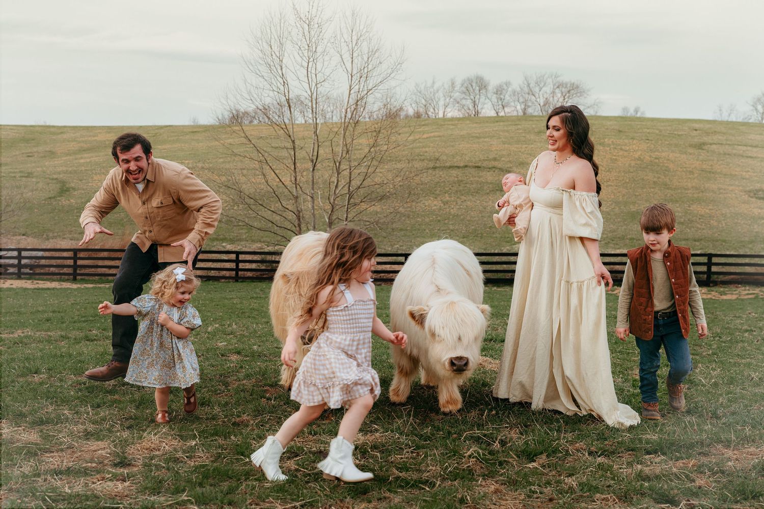 A playful outdoor family portrait session in a rustic field with vintage-inspired outfits and natural lighting.