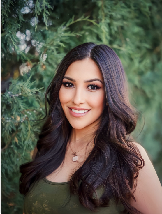 Professional portrait photos showing woman with long dark hair and natural makeup against green foliage background.
