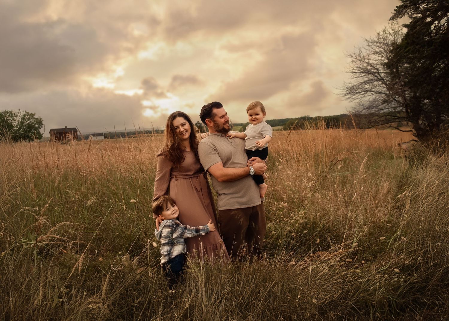Sunset family photoshoot in a golden field with warm autumn tones.