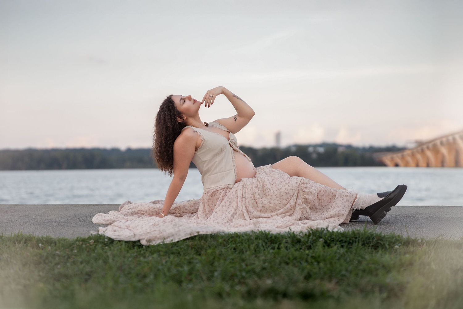 Maternity photo session on beach at sunset with flowing pink dress.