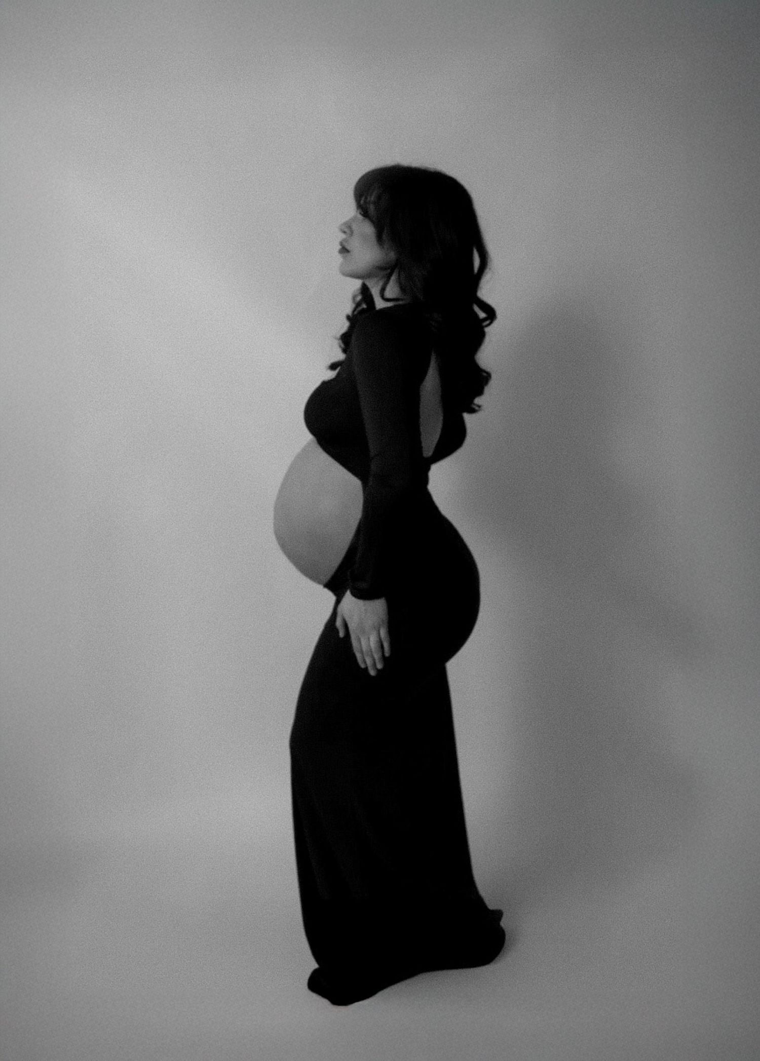 Artistic black and white silhouette series showing graceful pregnancy poses.