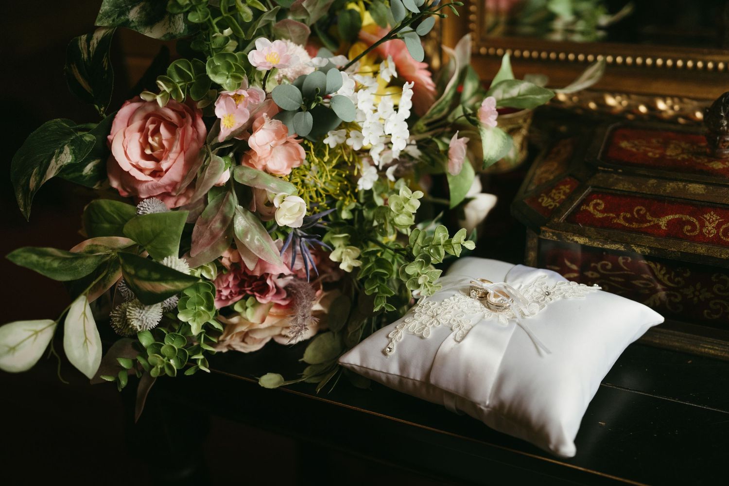 Elegant floral arrangement featuring pink roses and greenery against dark background.