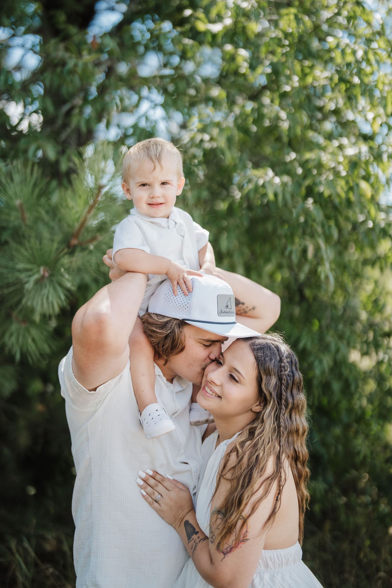 Couple sharing tender romantic moments outdoors against green foliage in a series of intimate portraits.