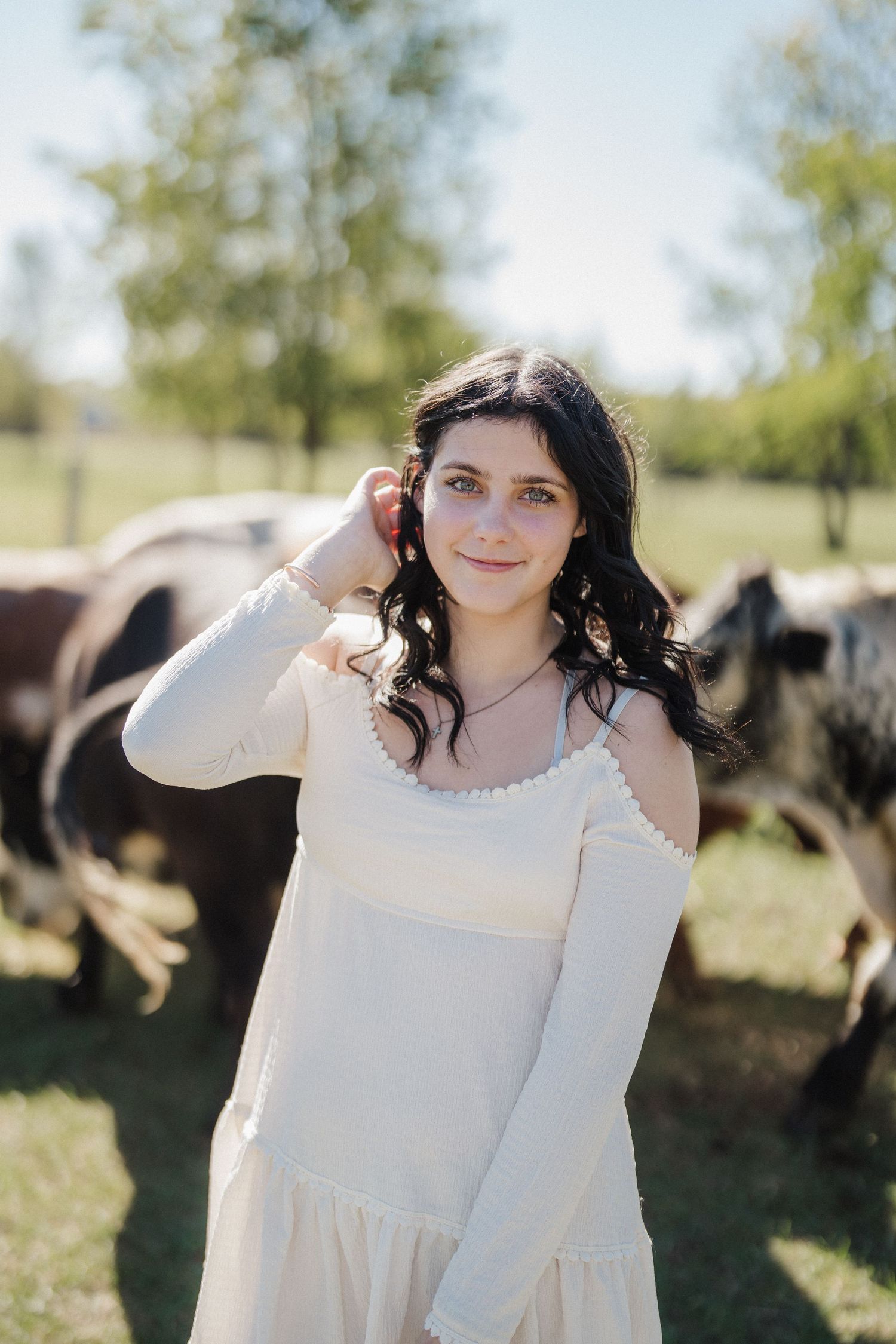 A series of outdoor portrait photos featuring someone in a white dress standing in a sunny field with trees.
