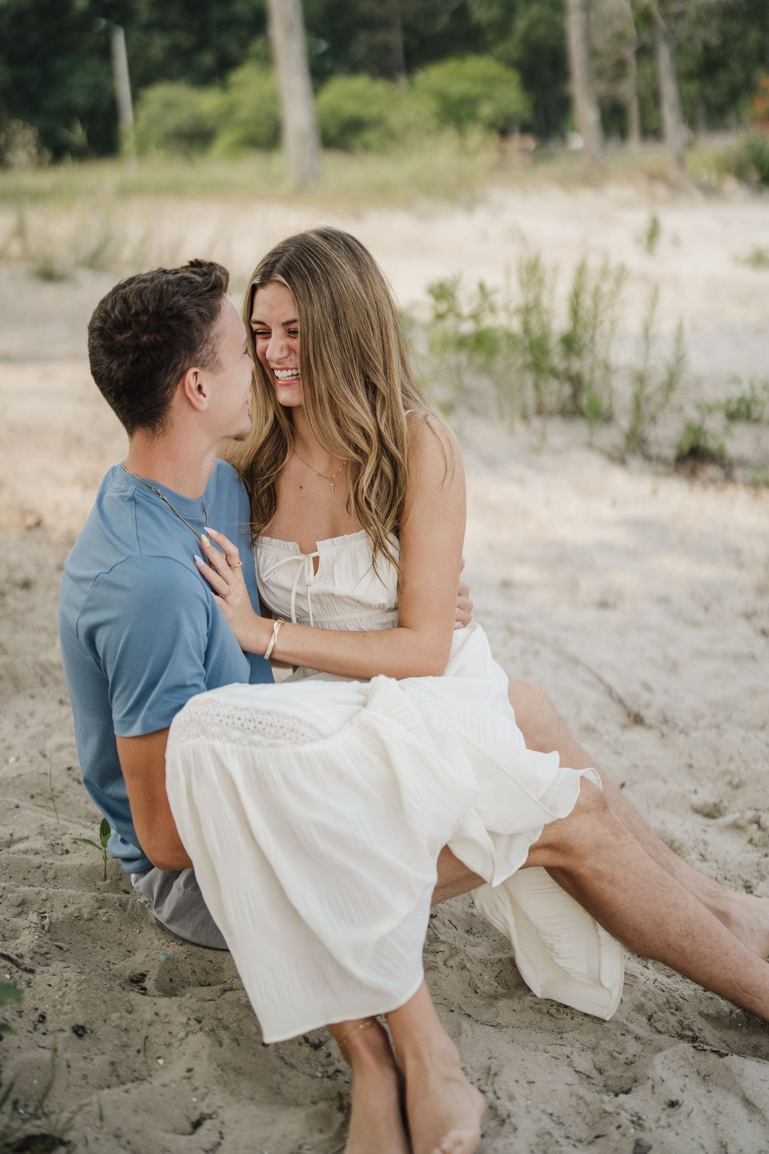 A romantic couple sits together on a sandy beach sharing intimate moments in a series of connected photos.