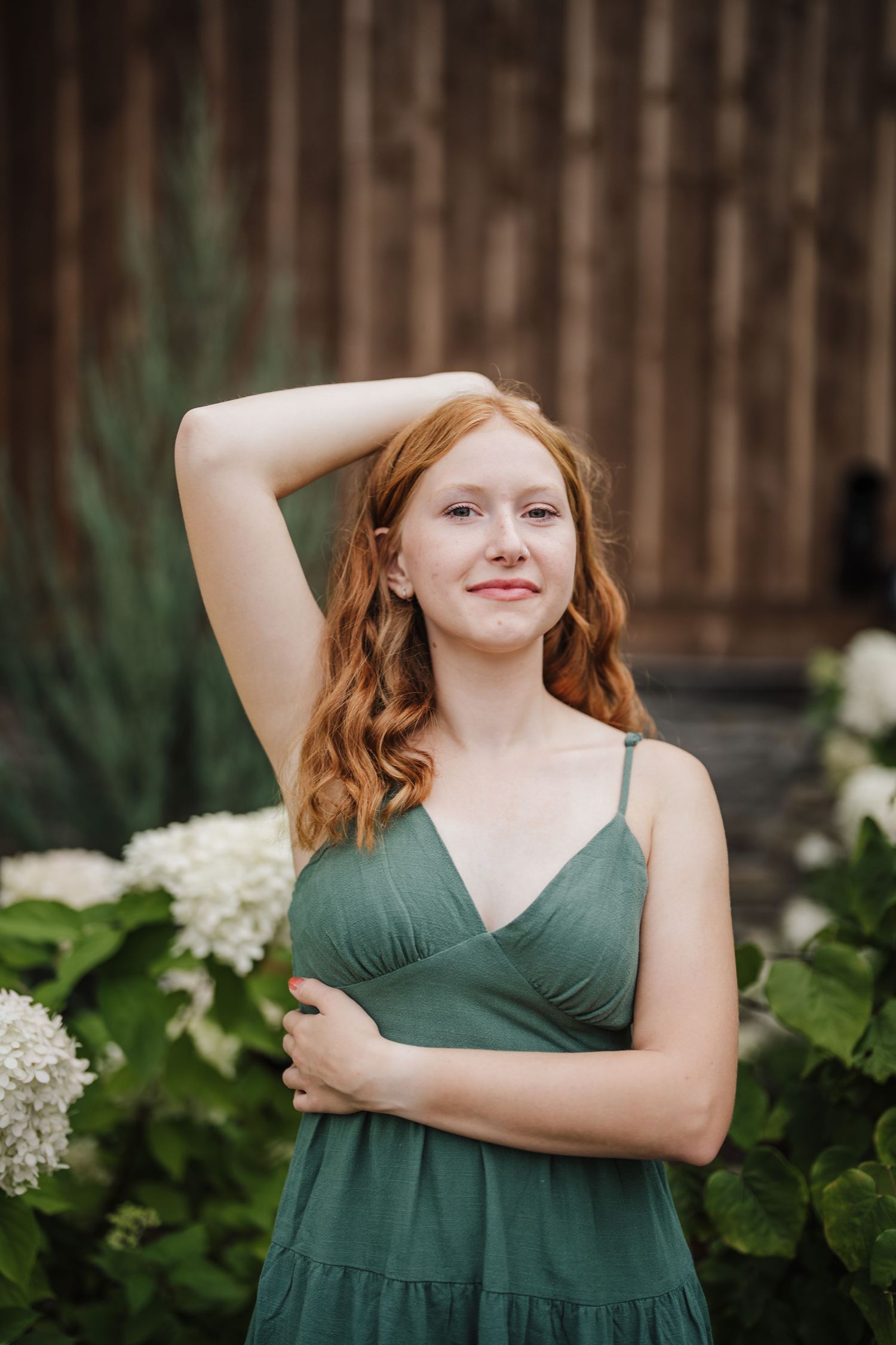 A sequence of photos showing someone in a green dress posing playfully against a garden backdrop with white flowers.