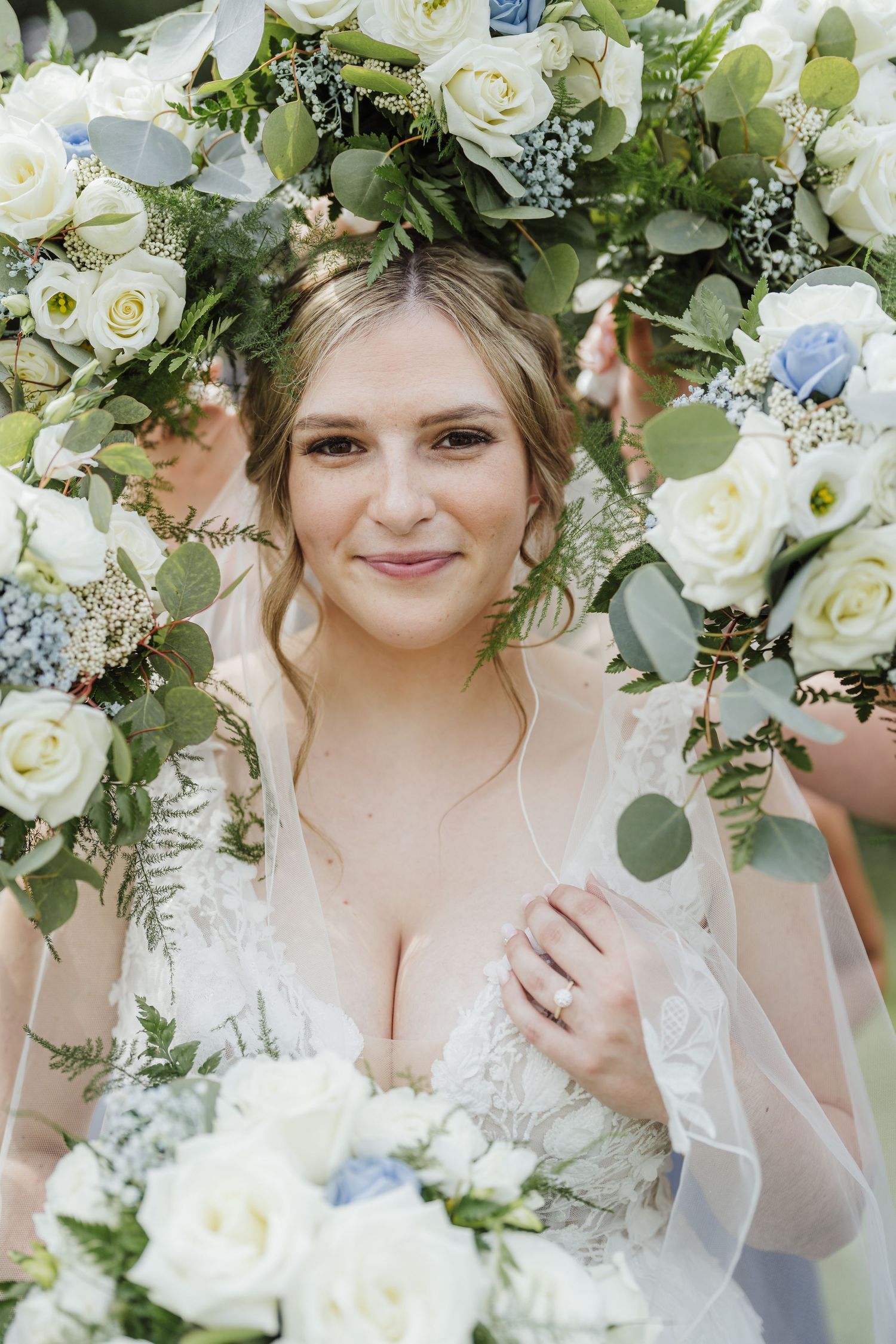 Beautiful bridal portrait framed by white roses and eucalyptus leaves.