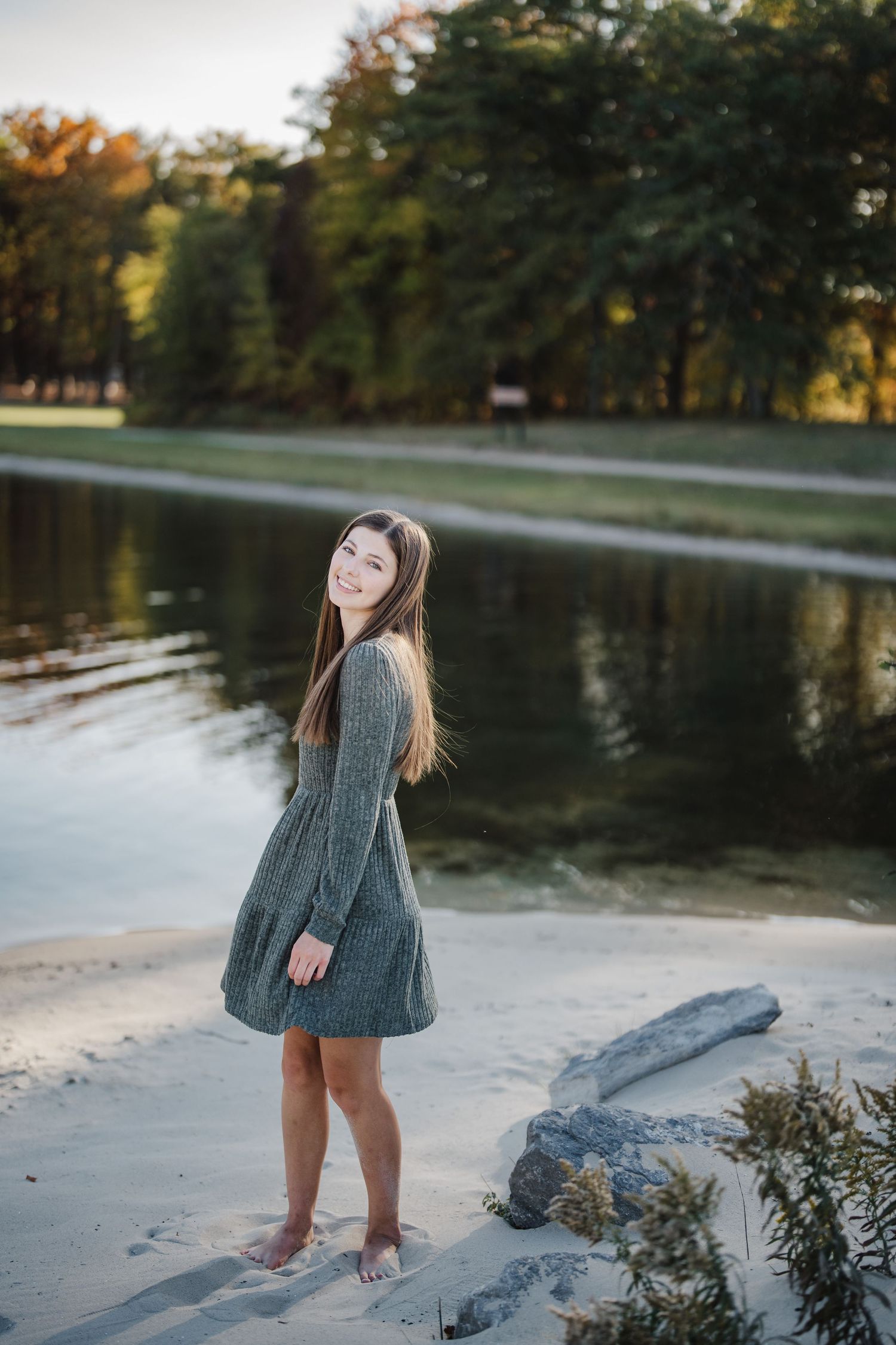 A series of photos showing a person in a gray sweater dress playing near a lake during autumn.
