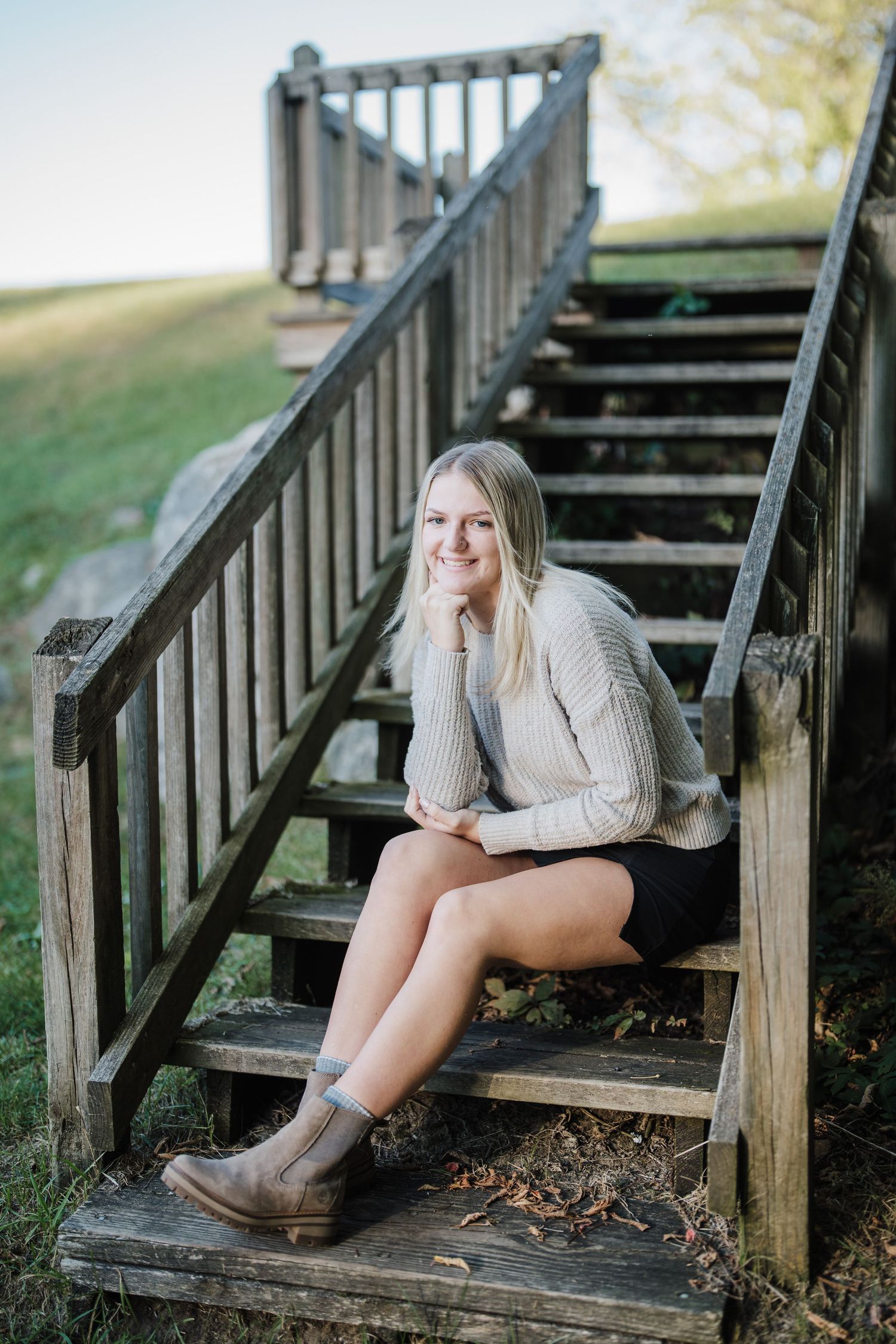 A series of outdoor portrait photos taken on wooden stairs showing someone wearing a cozy beige sweater and brown boots.