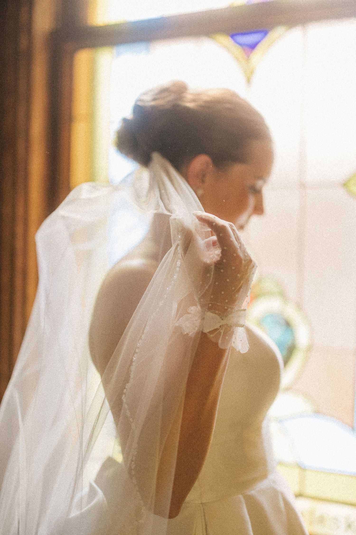 Artistic wedding photos show silhouettes against colorful stained glass church windows.